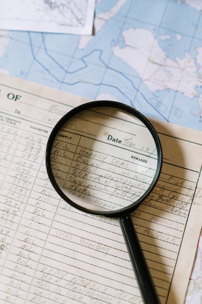 Close-up of a magnifying glass over a handwritten document on a map.